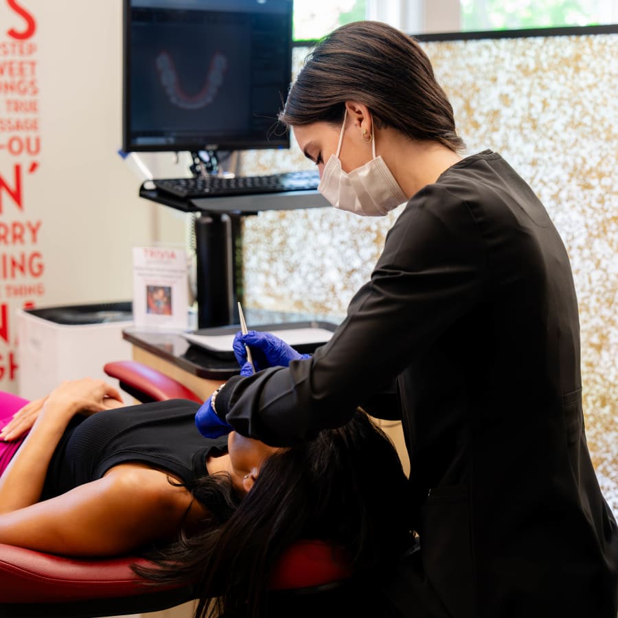 An adult patient is having her smile worked on by a Sturbridge Orthodontics team member.