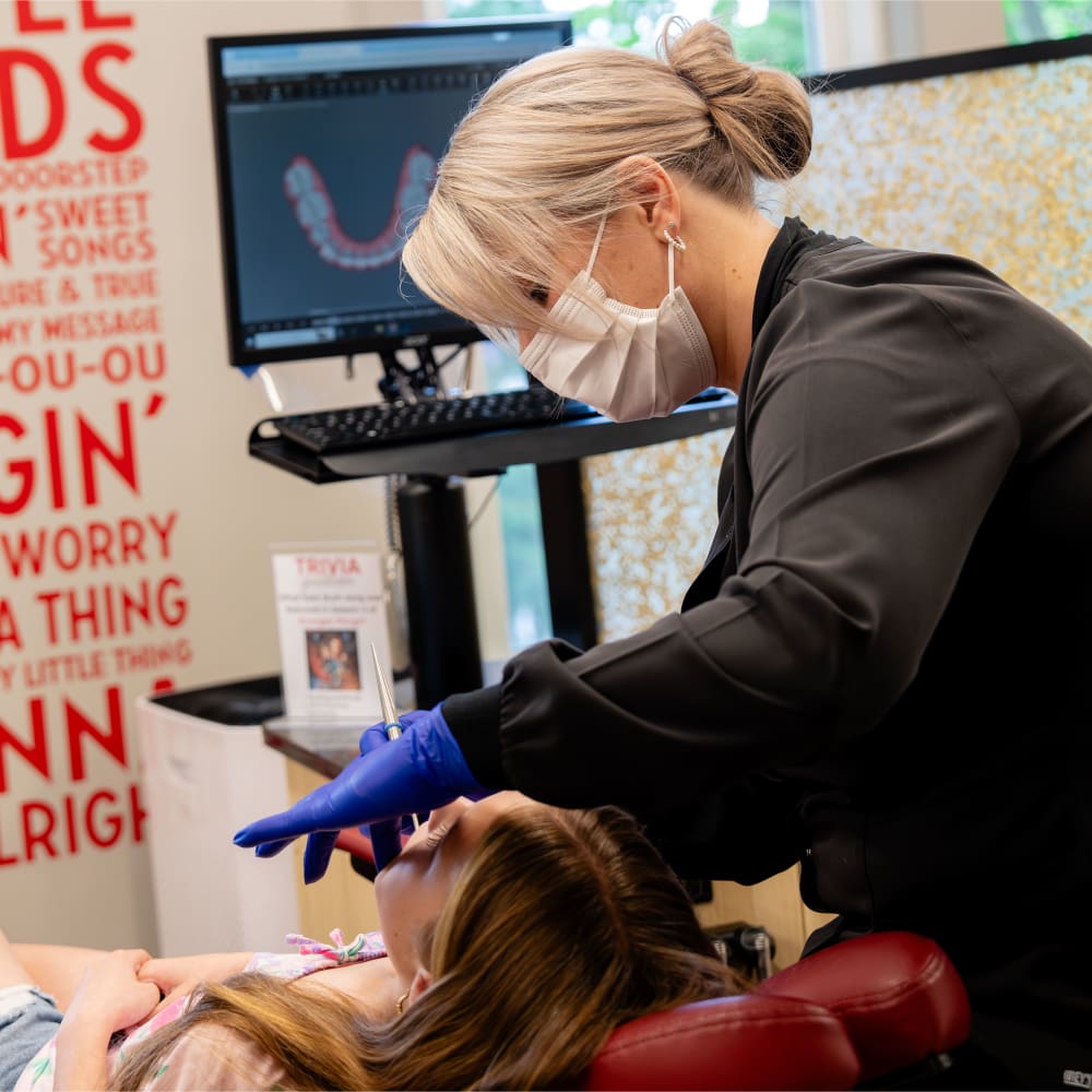 A team member at Sturbridge Orthodontics is taking a digital scan of a patient's teeth.