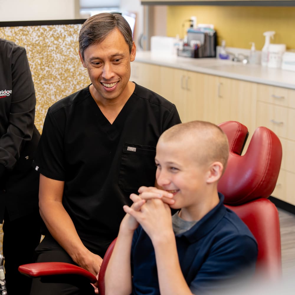 Dr. Sabelis and a team member at Sturbridge Orthodontics speak with a young patient.